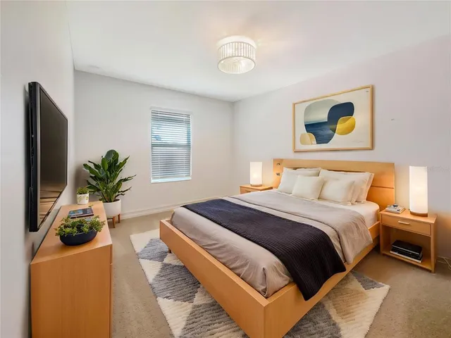 a bedroom with a bed and a potted plant