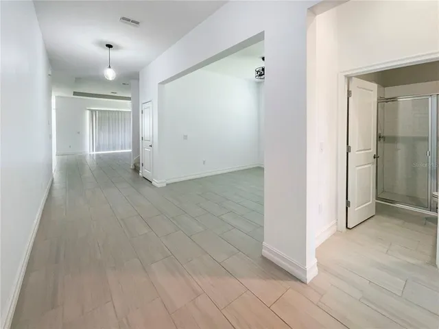 an empty room with wooden floor and mirror
