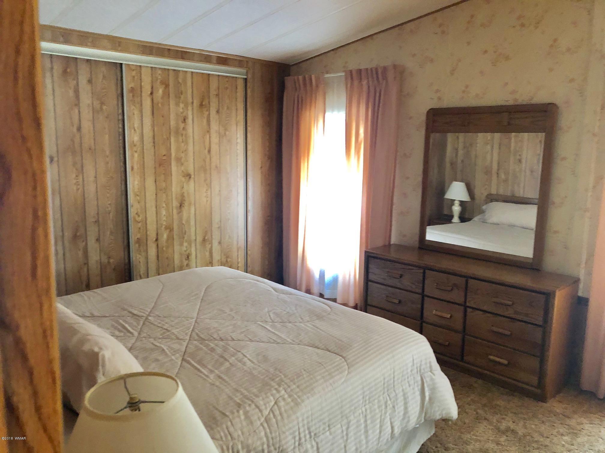 4288 Racoon Court Pinetop, AZ 85935 - Photo 14 of 29 a bedroom with a bed and a dresser with mirror