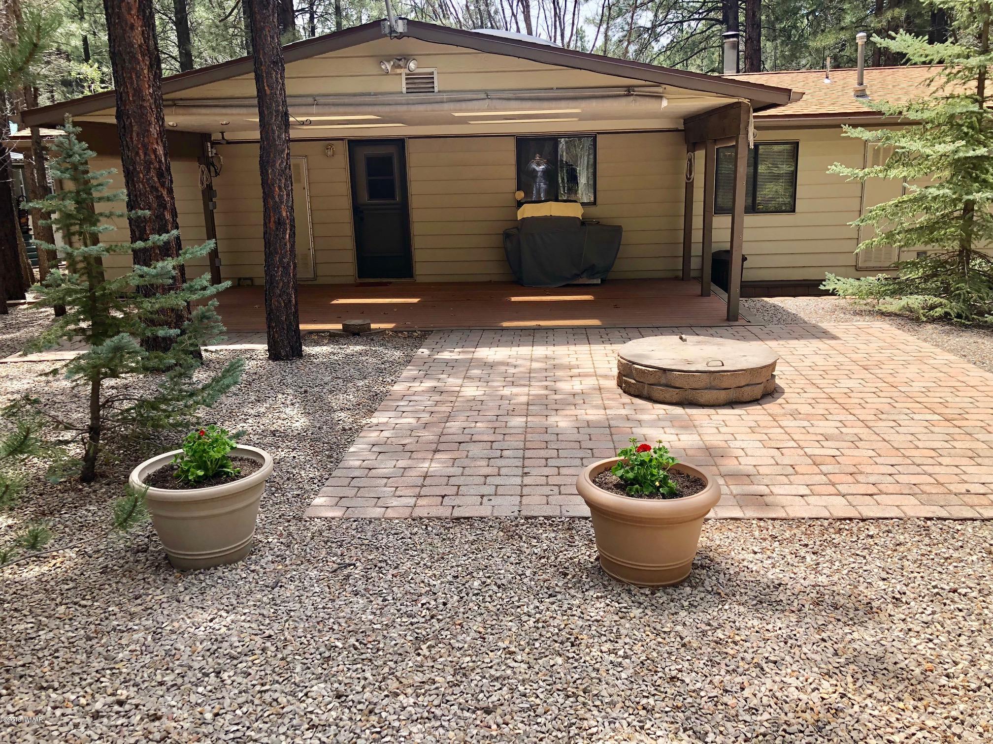 4288 Racoon Court Pinetop, AZ 85935 - Photo 21 of 29 a view of a backyard with table and chairs and potted plants