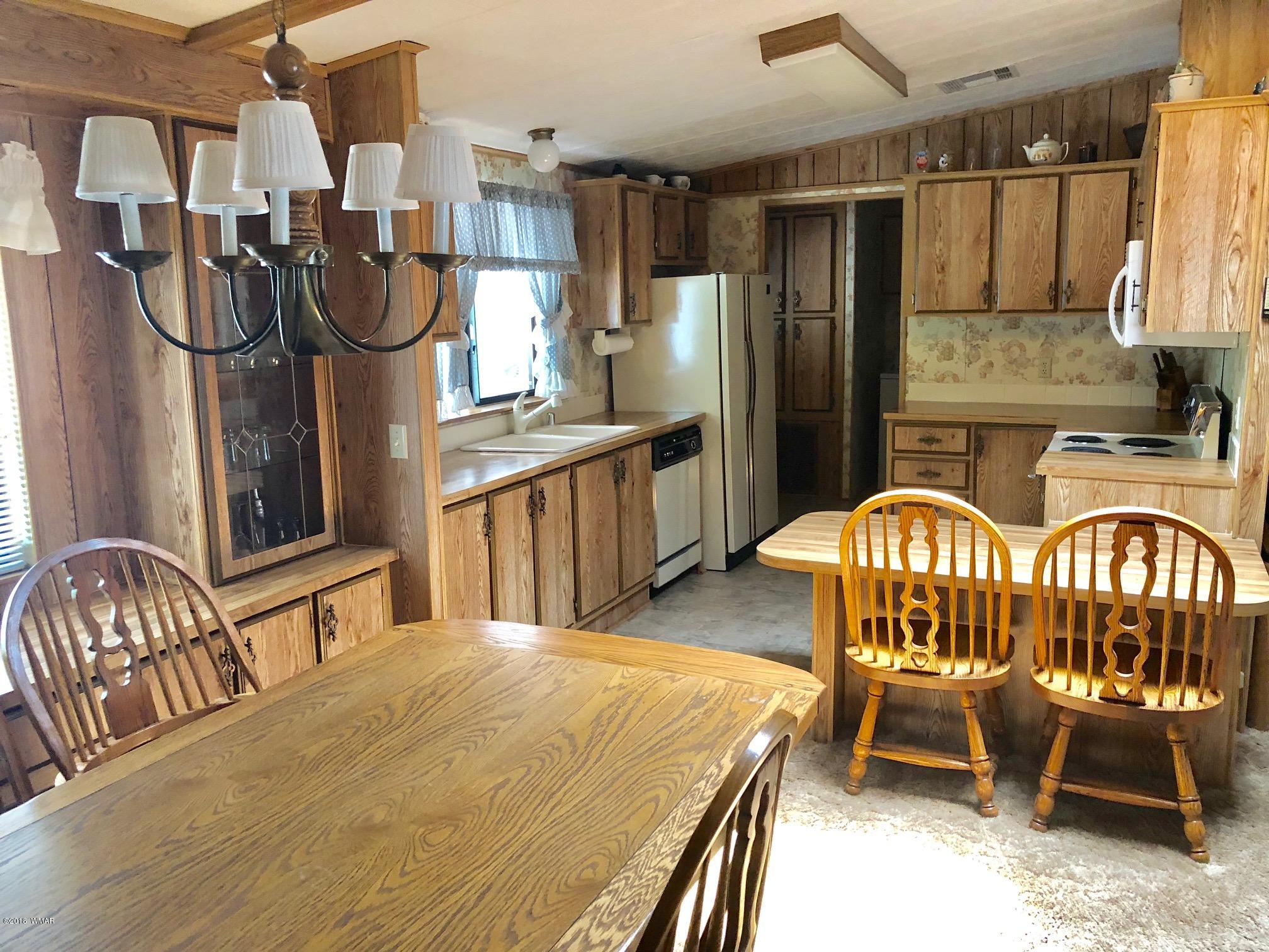 4288 Racoon Court Pinetop, AZ 85935 - Photo 8 of 29 a kitchen with stainless steel appliances granite countertop a dining table chairs in it and wooden floors