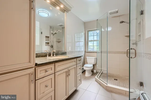 a bathroom with a double vanity sink toilet and shower
