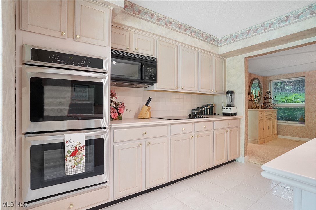 3680 Granger Road Akron, OH 44333 - Photo 8 of 40 Kitchen featuring black appliances, cream cabinets, light tile patterned floors, and backsplash