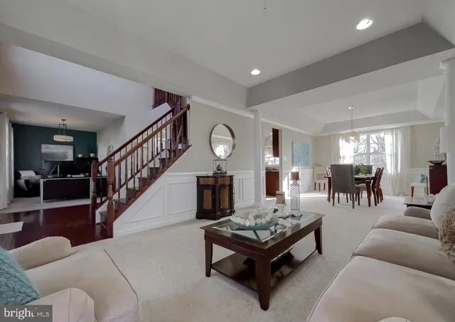a view of a dining room and livingroom with furniture a chandelier and wooden floor