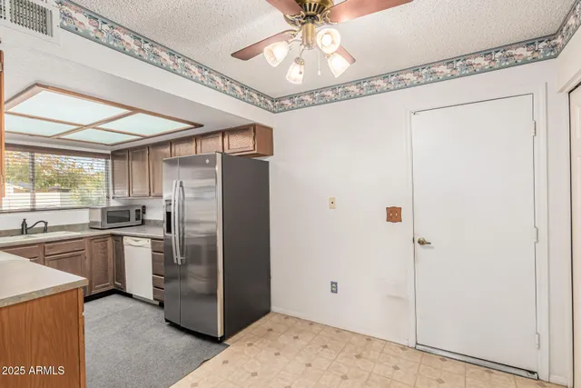 a kitchen with stainless steel appliances granite countertop a refrigerator and a sink