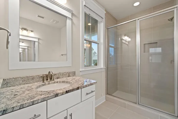 a bathroom with a granite countertop toilet a sink and a mirror