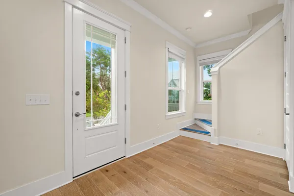 an empty room with wooden floor and windows