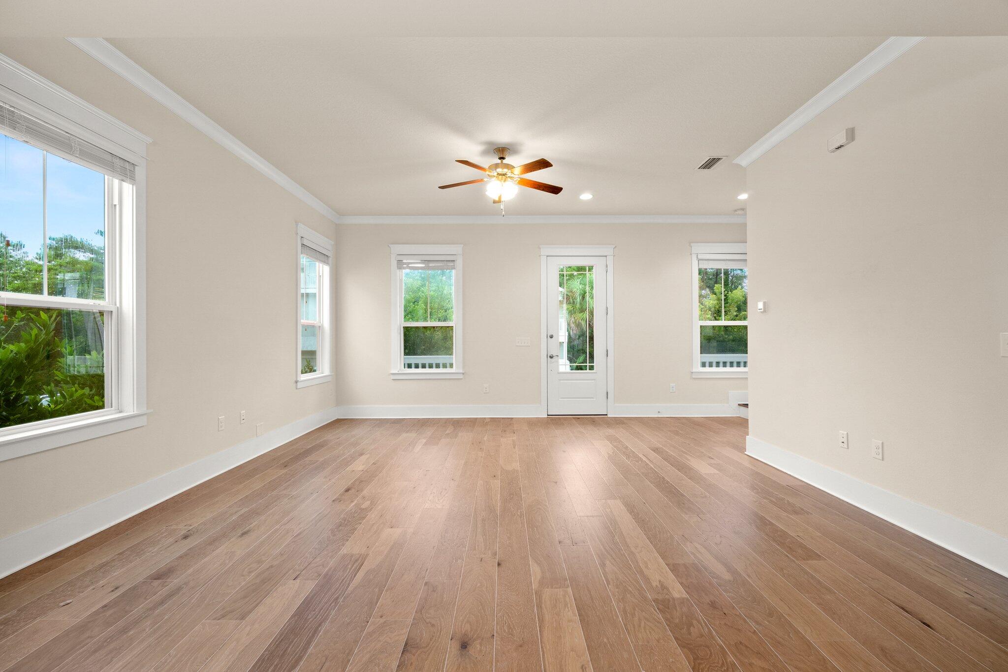 99 Grande Pointe Circle Inlet Beach, FL 32461 - Photo 6 of 34 an empty room with wooden floor ceiling fan and windows