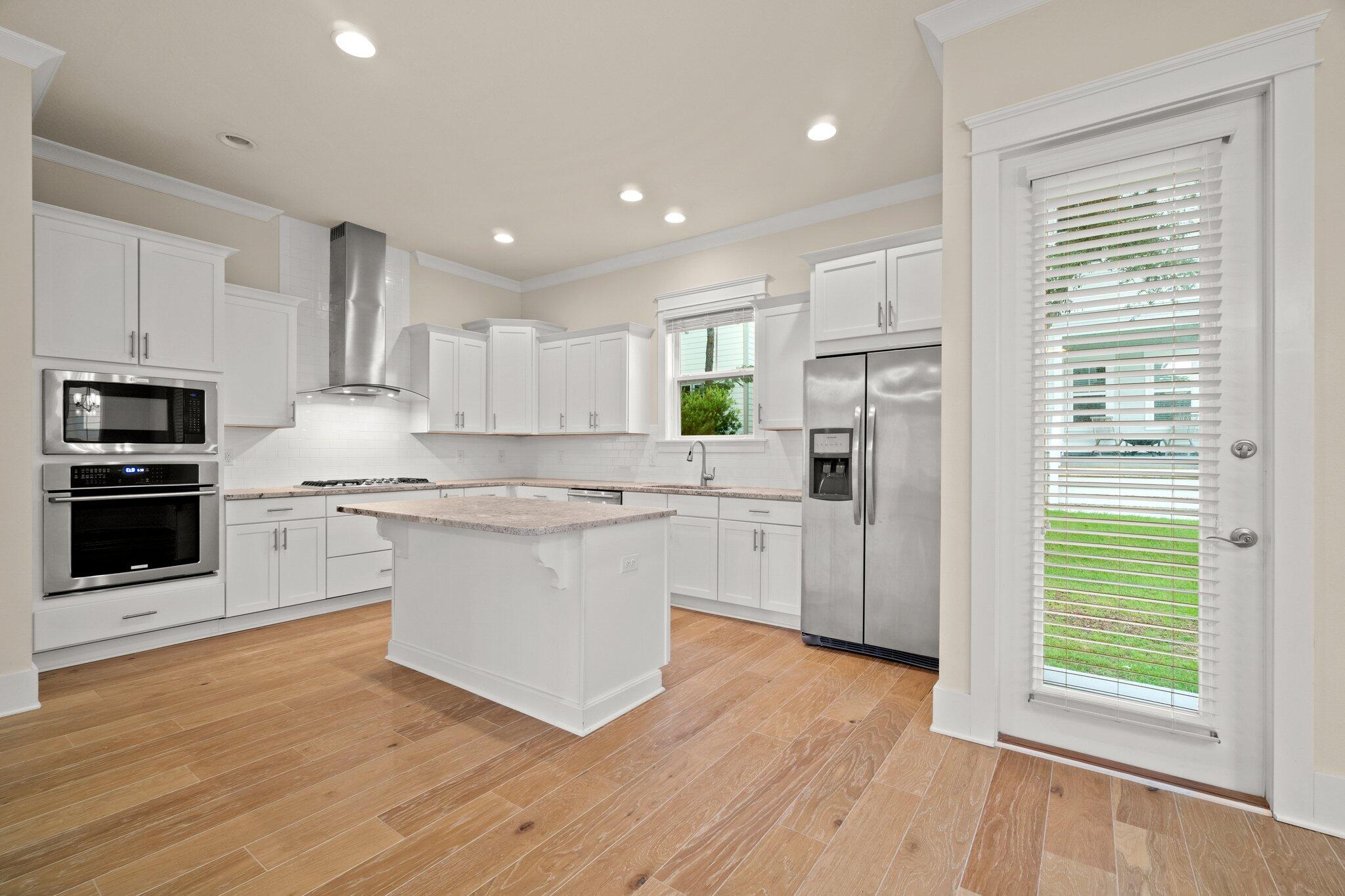 99 Grande Pointe Circle Inlet Beach, FL 32461 - Photo 8 of 34 a kitchen with white cabinets and stainless steel appliances