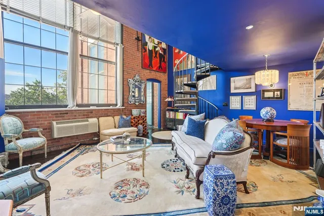 a living room with furniture a rug and a book shelf