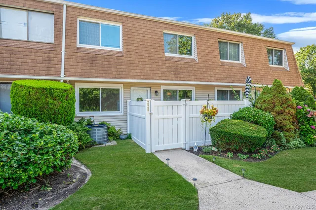 a view of a house with a small yard and wooden fence