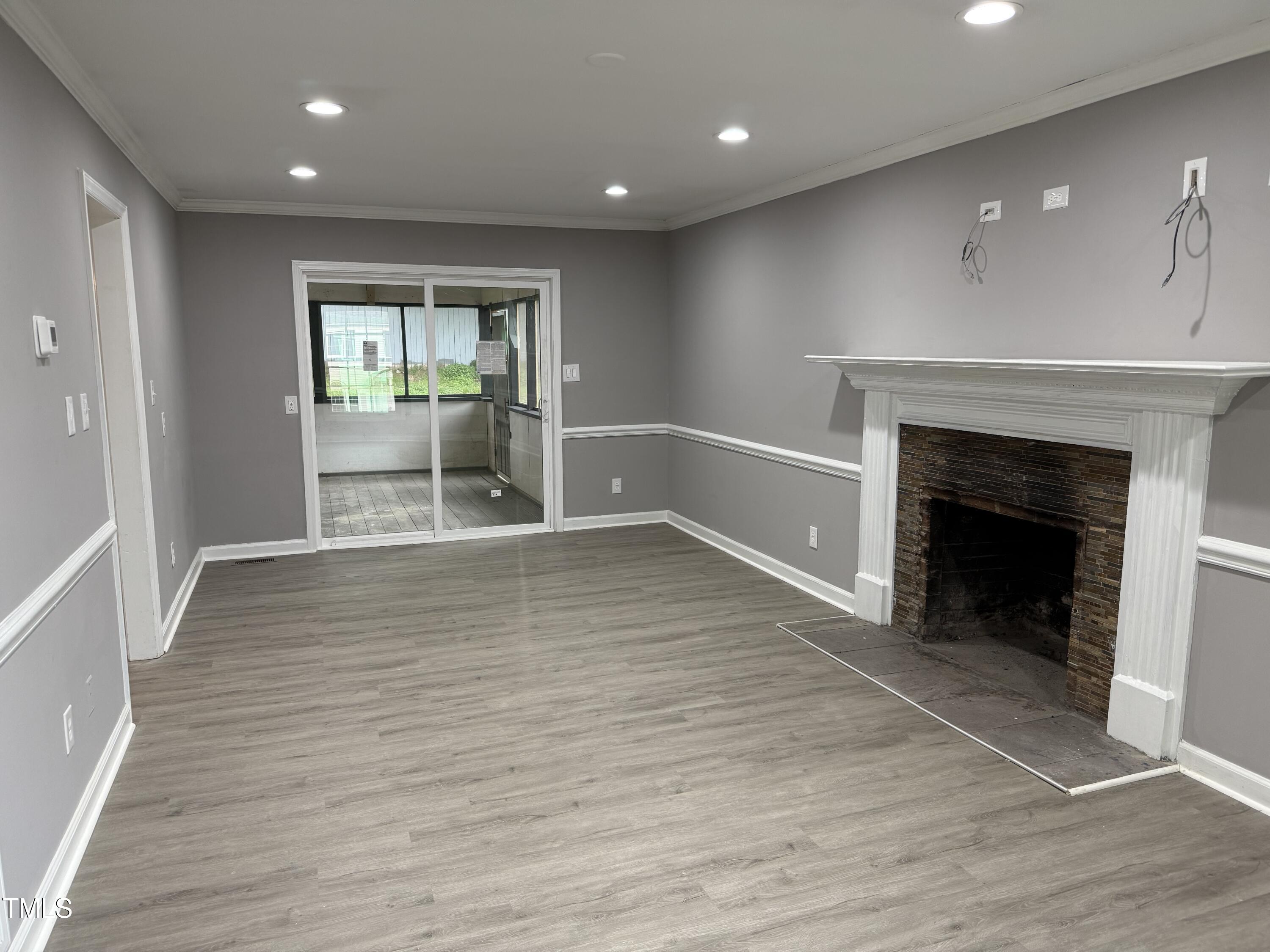 3825 Old Coach Road Raleigh, NC 27616 - Photo 2 of 31 an empty room with wooden floor and fireplace