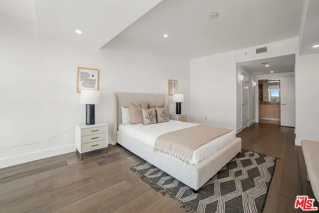 a bedroom with a bed and a painting on the wall