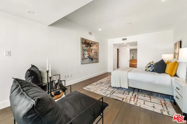 a bedroom with a bed and a lamp on dresser