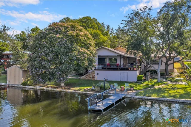 a view of house with swimming pool and yard