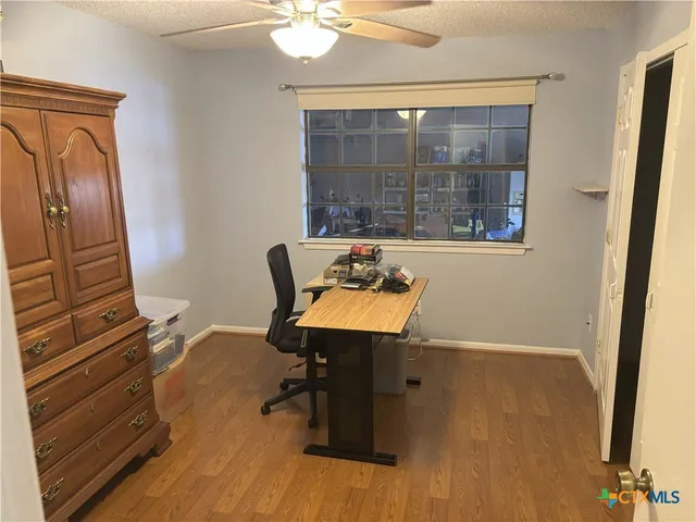 a view of a workspace with furniture and a window
