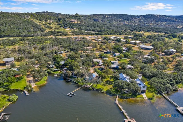 an aerial view of a houses with a street and trees