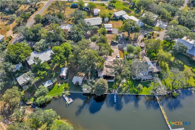 an aerial view of a house with a yard and lake view