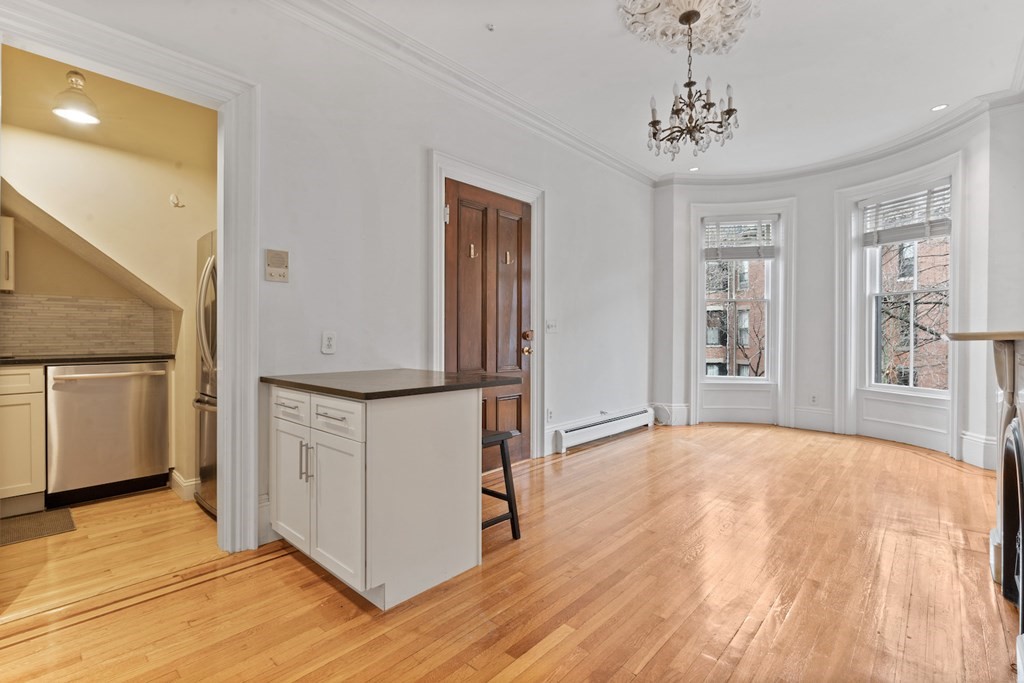 a view of an empty room with window and wooden floor