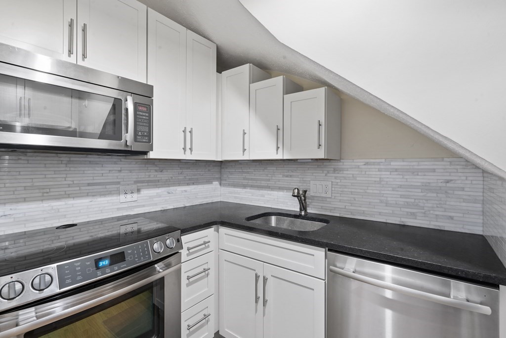 103 Appleton Street, Unit 3 Boston, MA 02116 - Photo 2 of 11 a kitchen with stainless steel appliances granite countertop white cabinets and a stove top oven