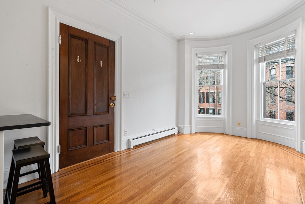 103 Appleton Street, Unit 3 Boston, MA 02116 - Photo 3 of 11 a view of an empty room with wooden floor and a window