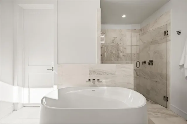 a white bath tub sitting in a bathroom and a shower