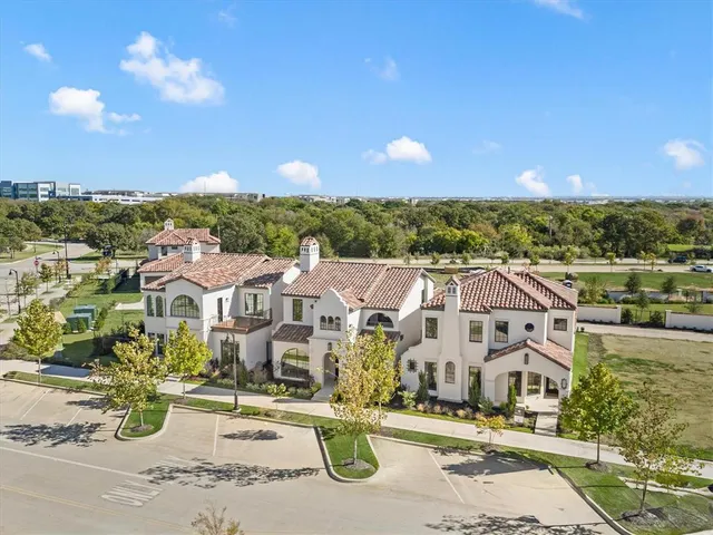 an aerial view of residential houses with outdoor space and street view
