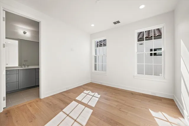 a view of empty room with windows and wardrobe