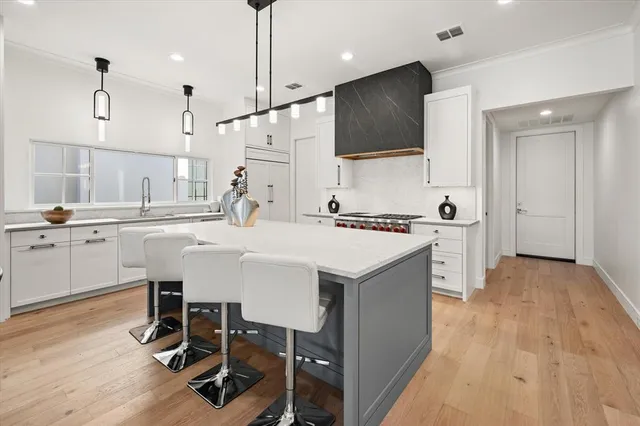 a kitchen with a sink a counter space appliances and cabinets