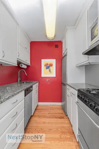 a kitchen with granite countertop a stove and cabinets