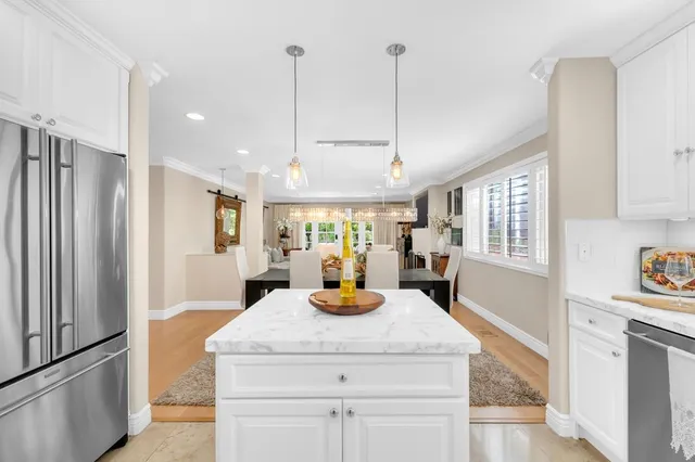 a kitchen with a refrigerator and white cabinets