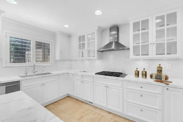 a kitchen with stainless steel appliances granite countertop white cabinets and a stove