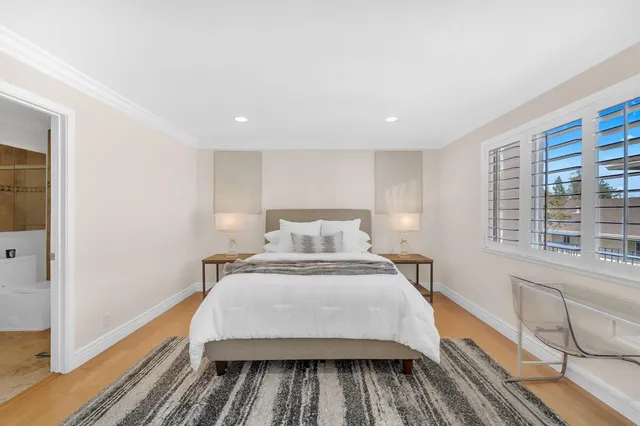 a spacious bedroom with a bed a table and chair