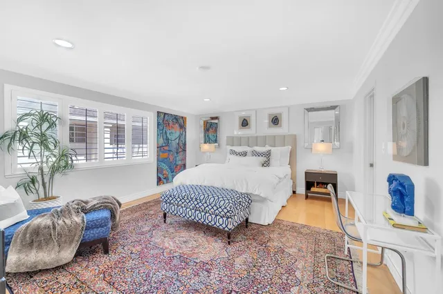 a bedroom with a bed and painting on the wall