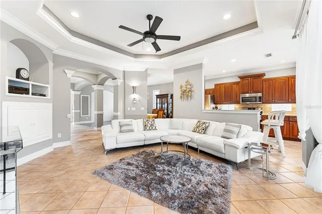a living room with furniture kitchen view and a wooden floor