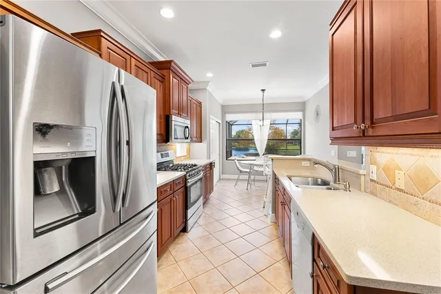 a kitchen with stainless steel appliances granite countertop a refrigerator a sink a stove and island