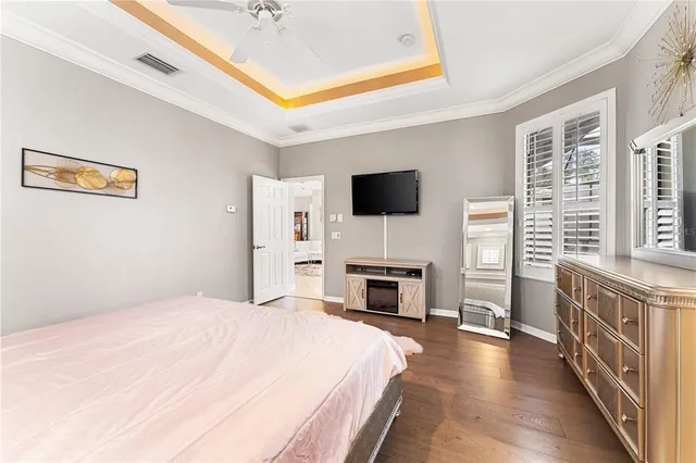 a spacious bedroom with a bed and a flat screen tv