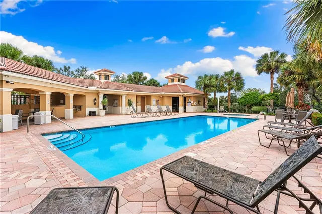 a view of a house with pool and chairs