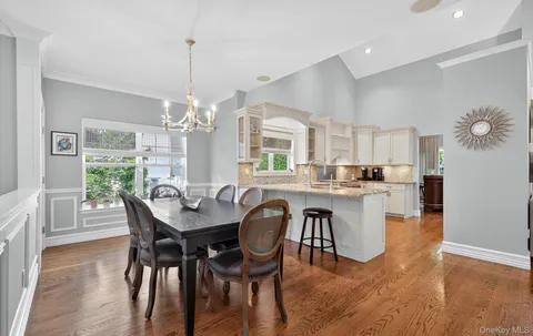 a dining room filled chandelier and wooden floor