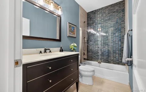a bathroom with a granite countertop sink toilet a mirror a vanity and shower