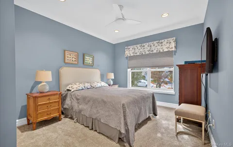 a bedroom with a bed window and a television