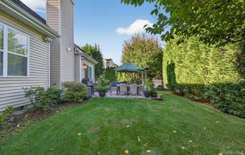 a view of a house with a yard and sitting area