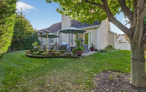 a view of a house with backyard and sitting area