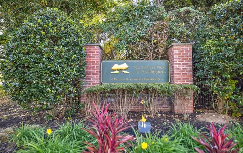 a sign that is sitting in front of a tree