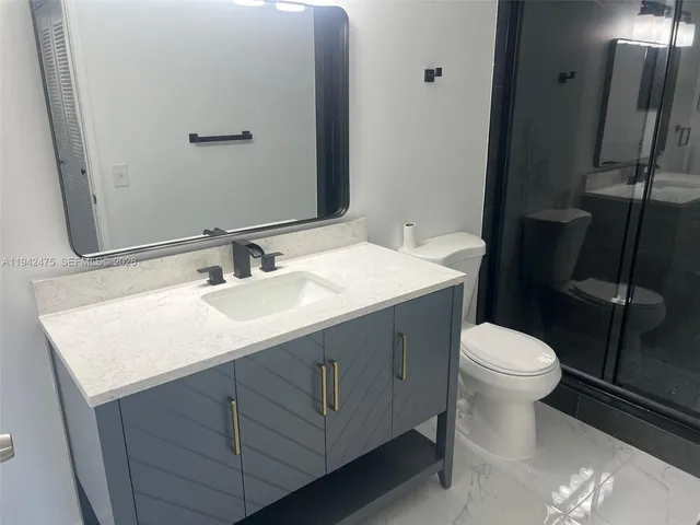 a bathroom with a sink toilet and mirror