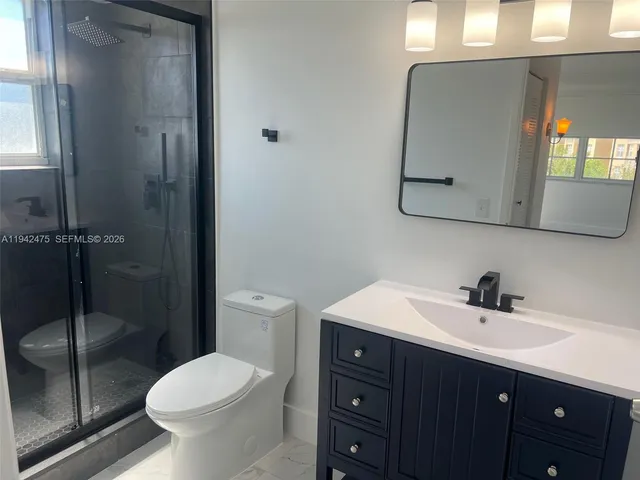 a bathroom with a double vanity sink toilet and mirror