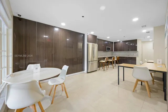 a view of kitchen with furniture and refrigerator