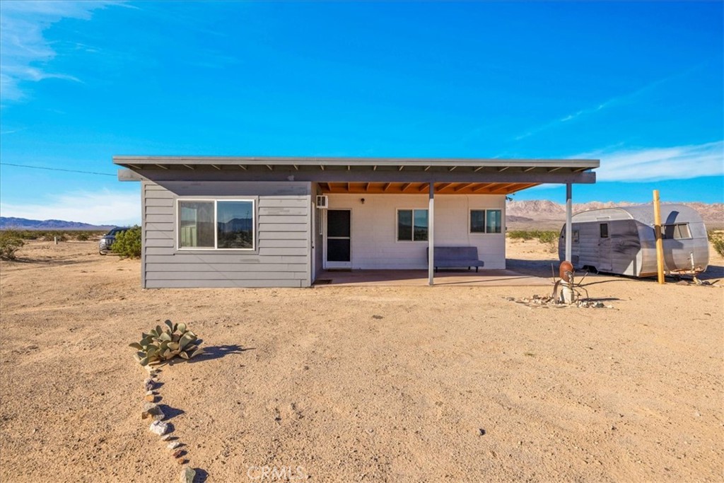 84753 Eddie Albert Road Twentynine Palms, CA 92277 - Photo 1 of 52 a backyard of a house with barbeque oven table and chairs