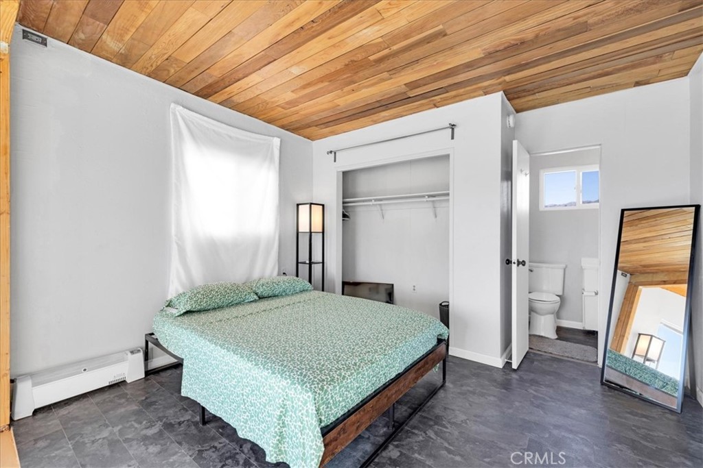 84753 Eddie Albert Road Twentynine Palms, CA 92277 - Photo 16 of 52 a bedroom with a bed and a flat screen tv