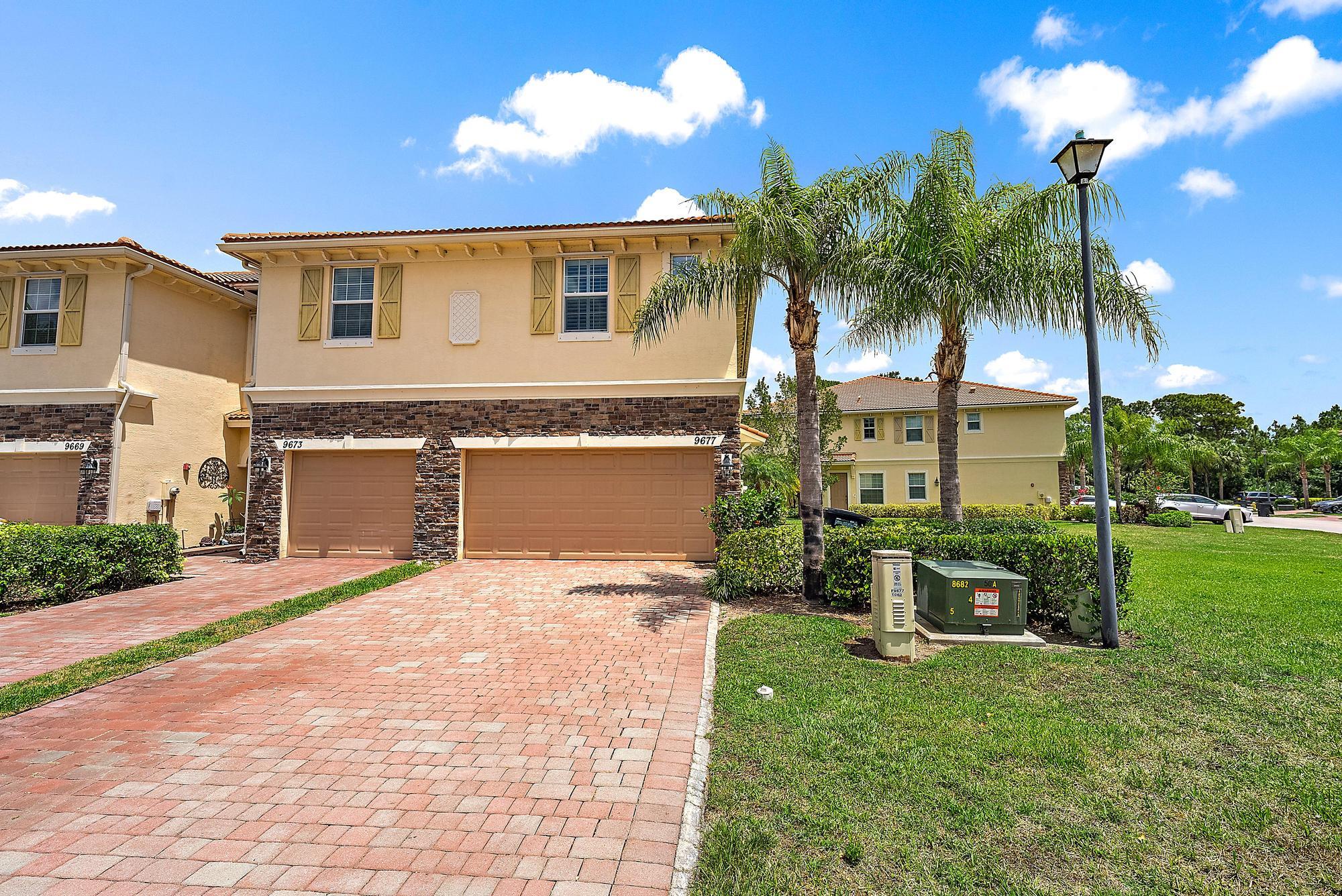 a front view of a house with a yard and palm trees